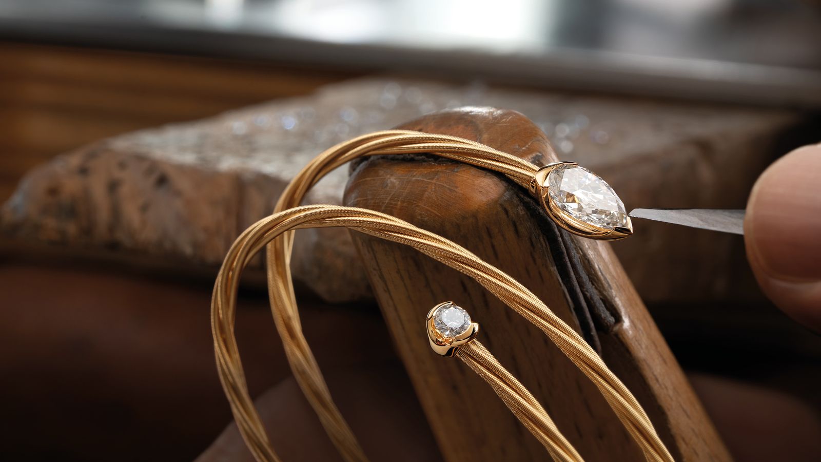 Das Herzstück des Armbands UMARME MICH Power of diamond drop aus 18 Karat Gelbgold ist der funkelnde Diamanttopf und der gegenüberliegende Solitär mit einer persönlichen Gravur.