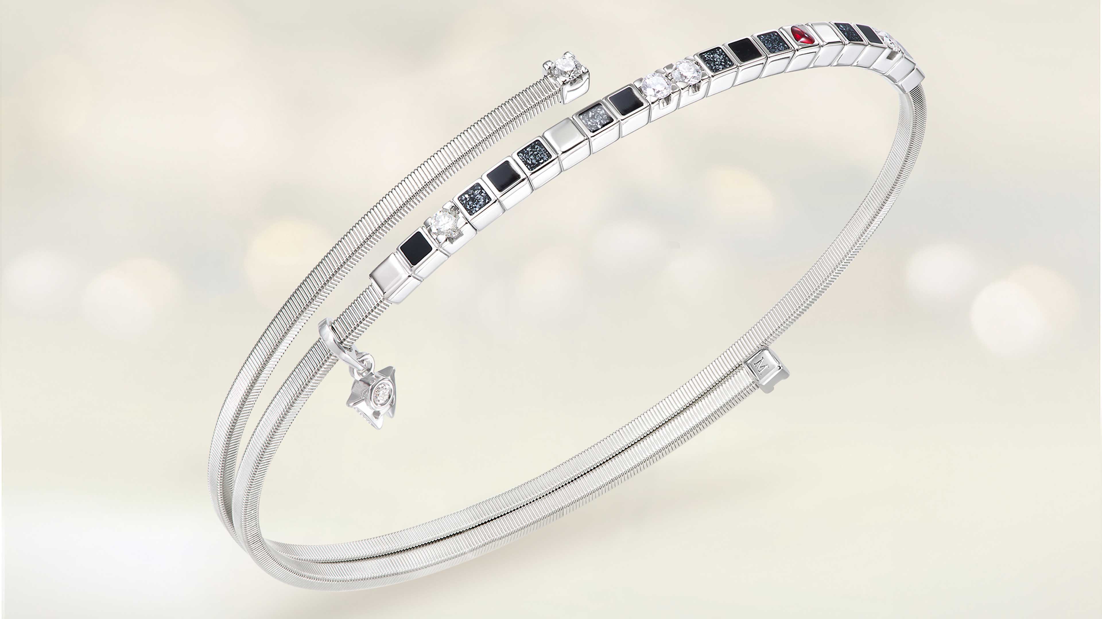 Das Armband POWER IN BLACK aus 18 Karat Weißgold aus schwarzer Kaltemaille mit Sternenstaub, rotes Herz und funkelnde Brillanten auf hellem Hintergrund.