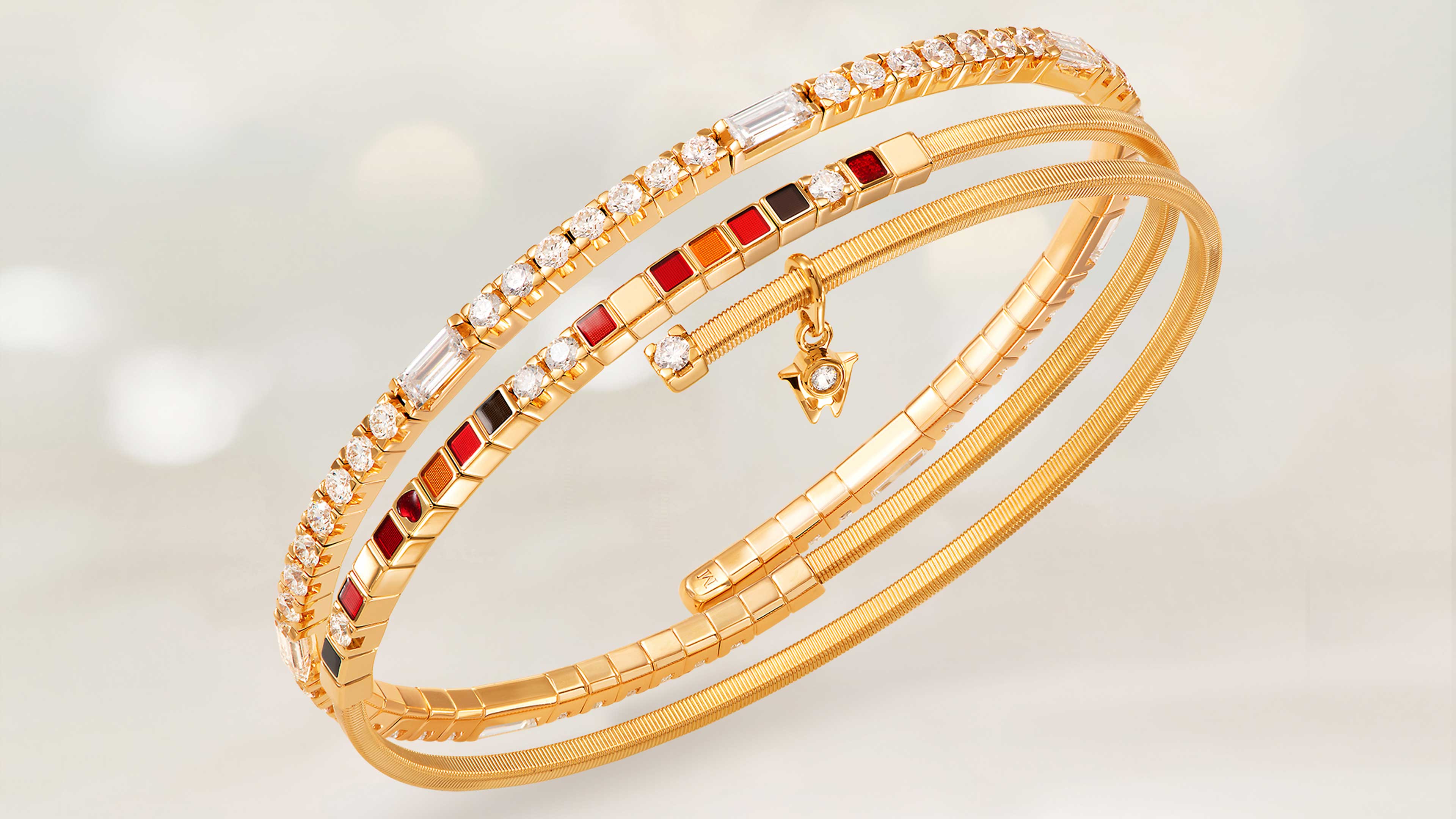 Das Wellendorff Armband UMARME MICH Power in red edel in 18-Karat Gelbgold auf beigem Mood Hintergrund