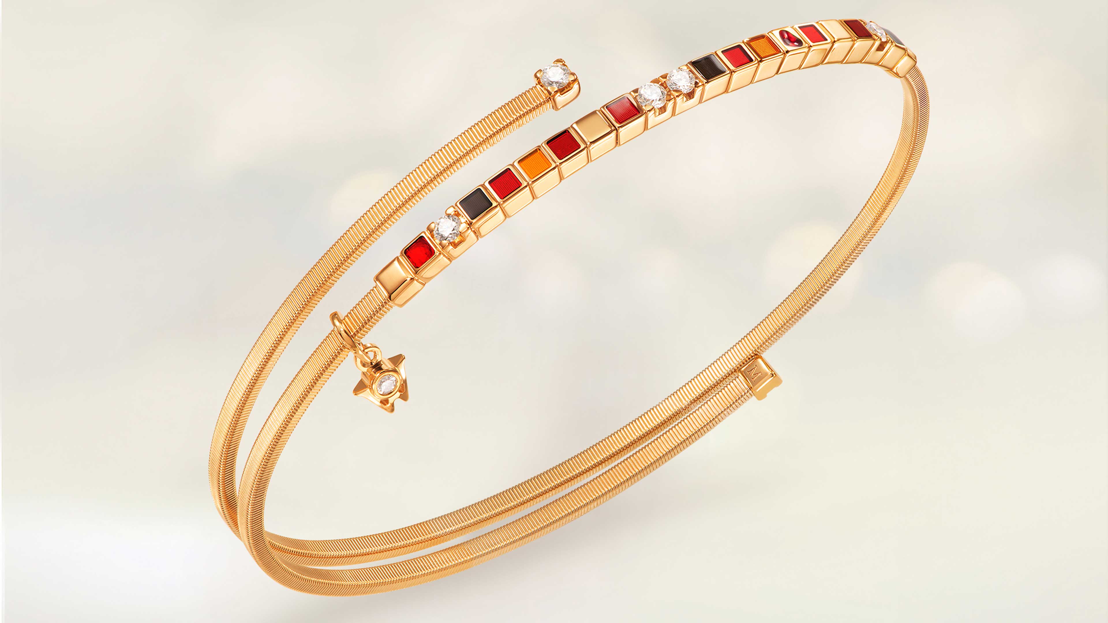 Das Wellendorff Armband UMARME MICH Power in red in 18-Karat Gelbgold auf beigem Mood Hintergrund