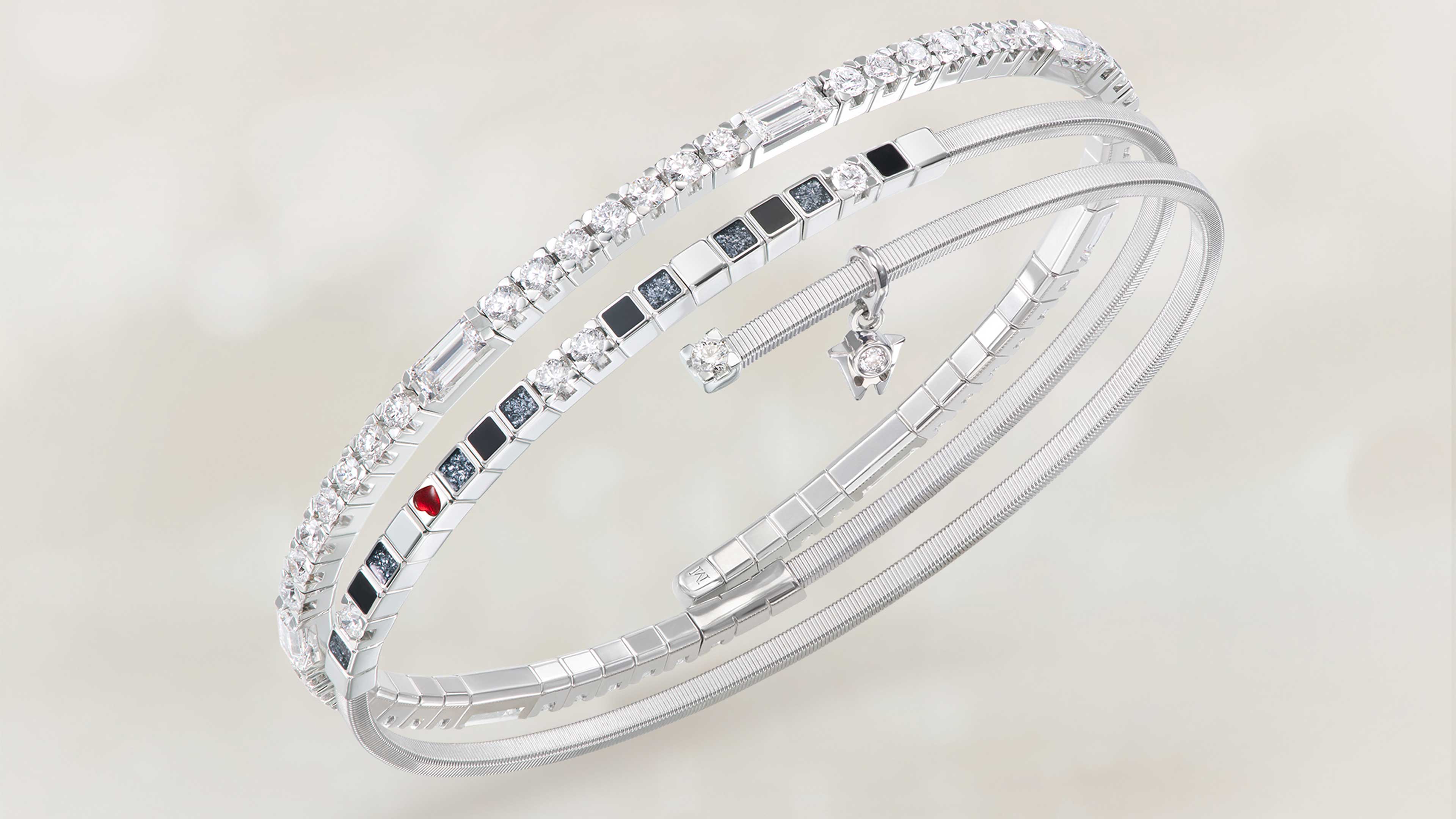 Das Wellendorff Armband UMARME MICH Power in black edel in 18-Karat Weißgold auf beigem Mood Hintergrund