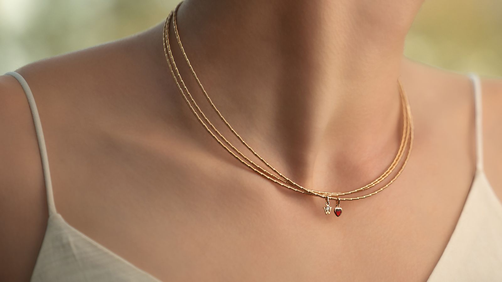 Das Collier MEIN HERZ Trio aus seidenweichem 18-karätigem Gold mit einem romantischen Herz gefüllt mit Wellendorff-Kaltemaille. Getragen von einem Model.