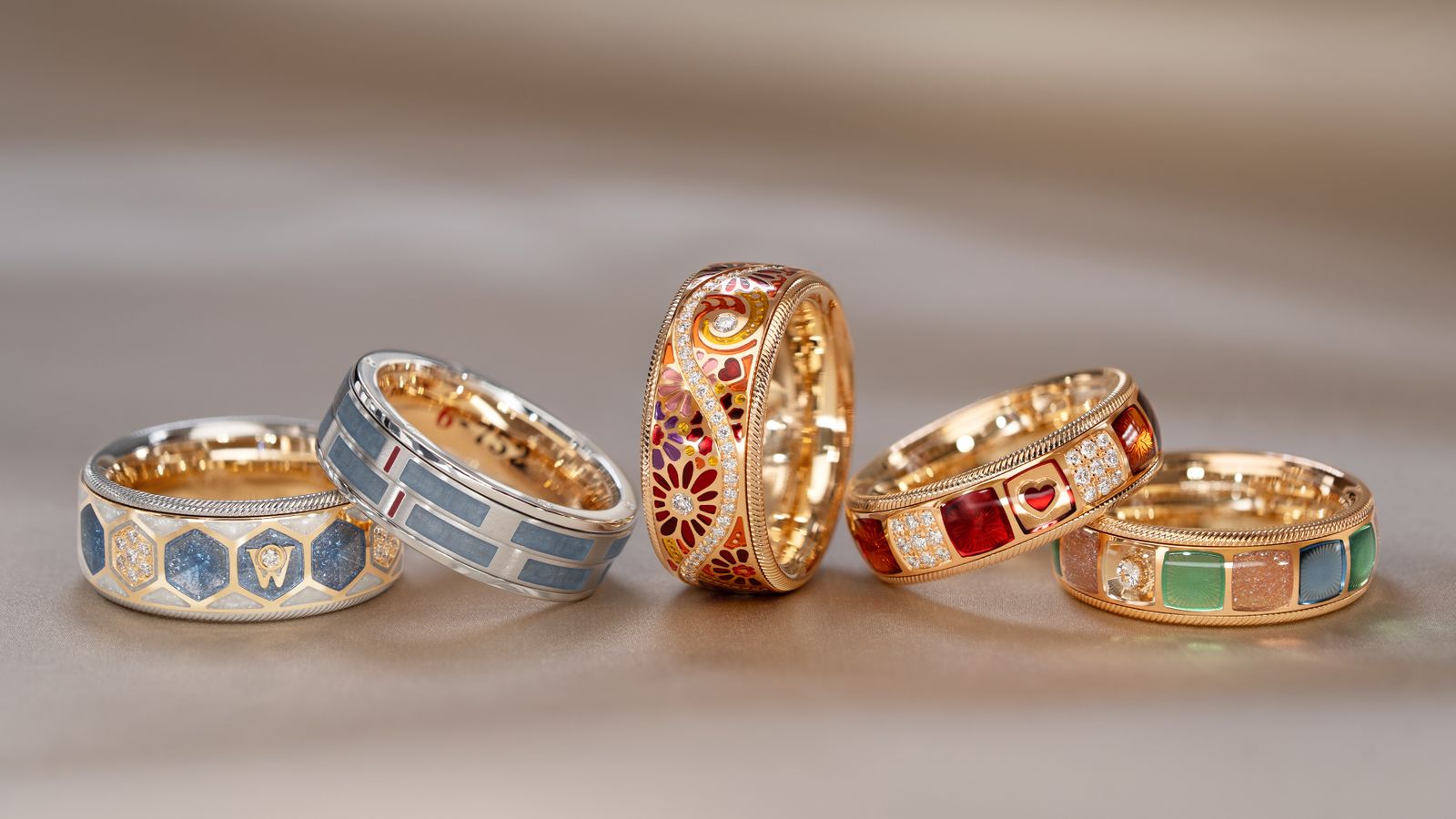 Die fünf Geburtstagsringe von Wellendorff: in 18 Karat Gold, bunter Kaltemaille und handgefassten Brillanten. 5 Ringe auf hellem Hintergrund.