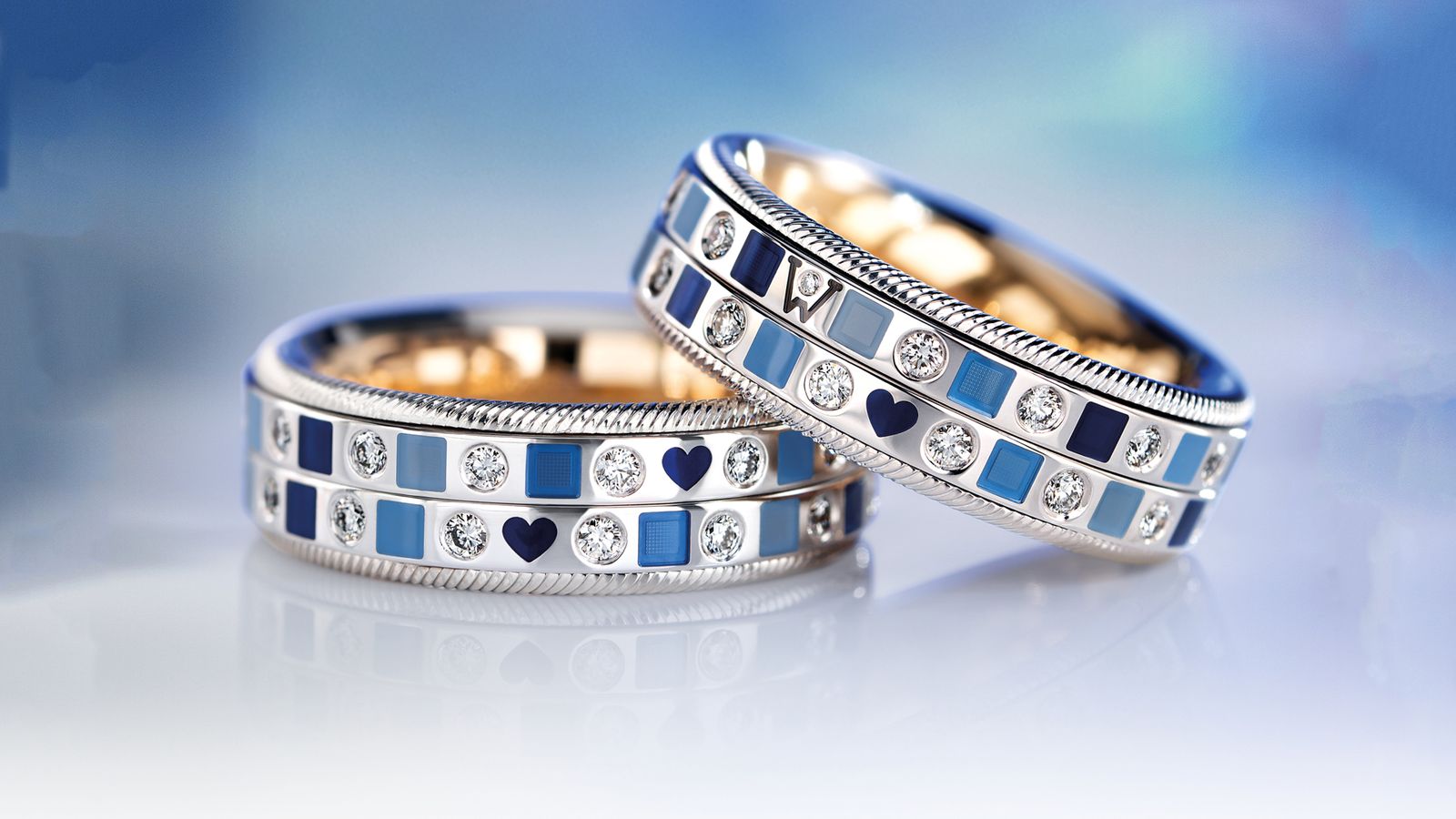 Der drehbare Ring OZEAN Duett aus 18 Karat Gold mit modernen, tiefblauen Mosaiken aus Wellendorff-Kaltemaille und handgefassten Brillanten. In einem Moodbild.