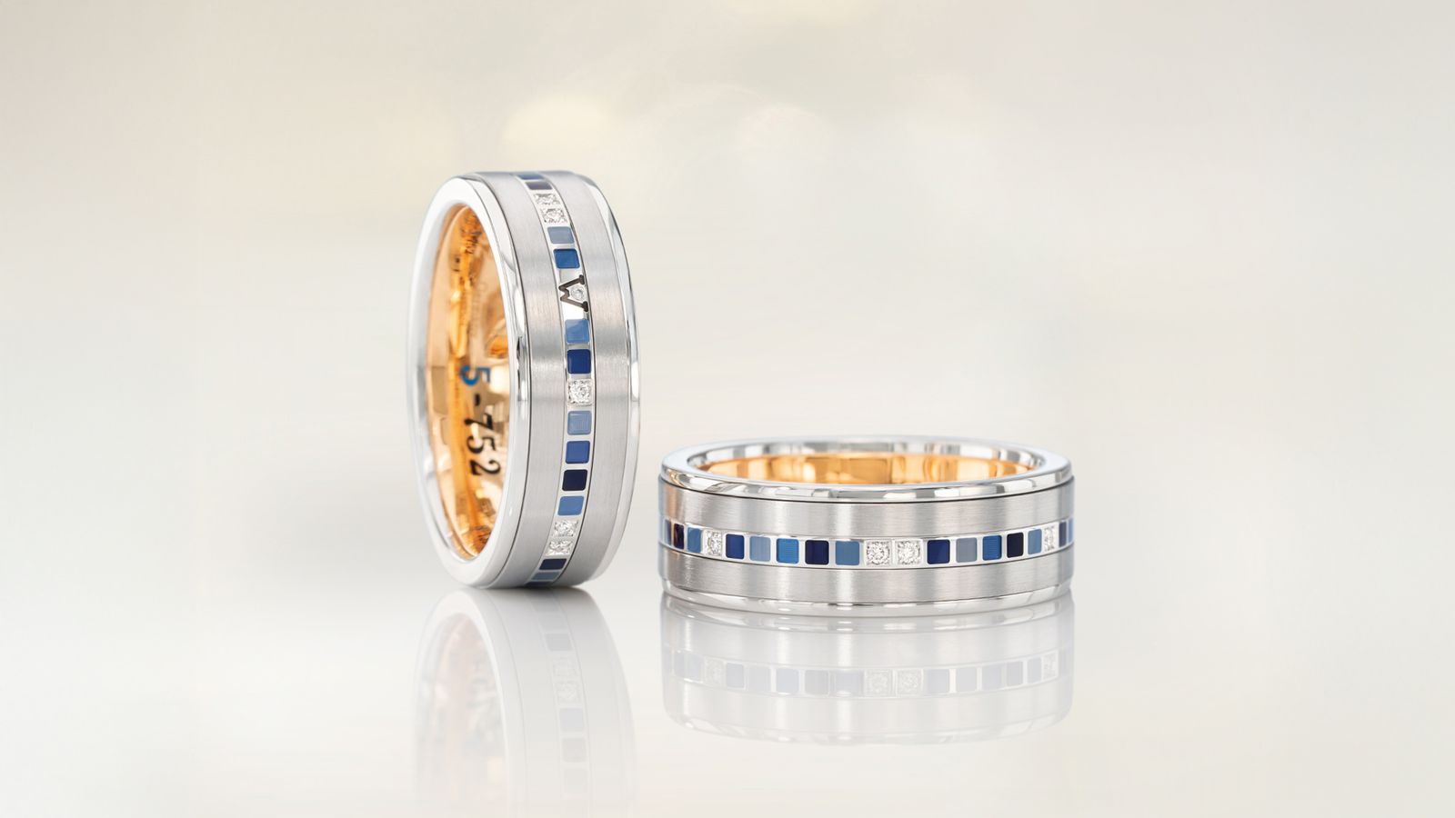 Der Herrenring 5-752 mit 18 Karat Weißgold und blauen Mosaiken aus Wellendorff-Kaltemaille.