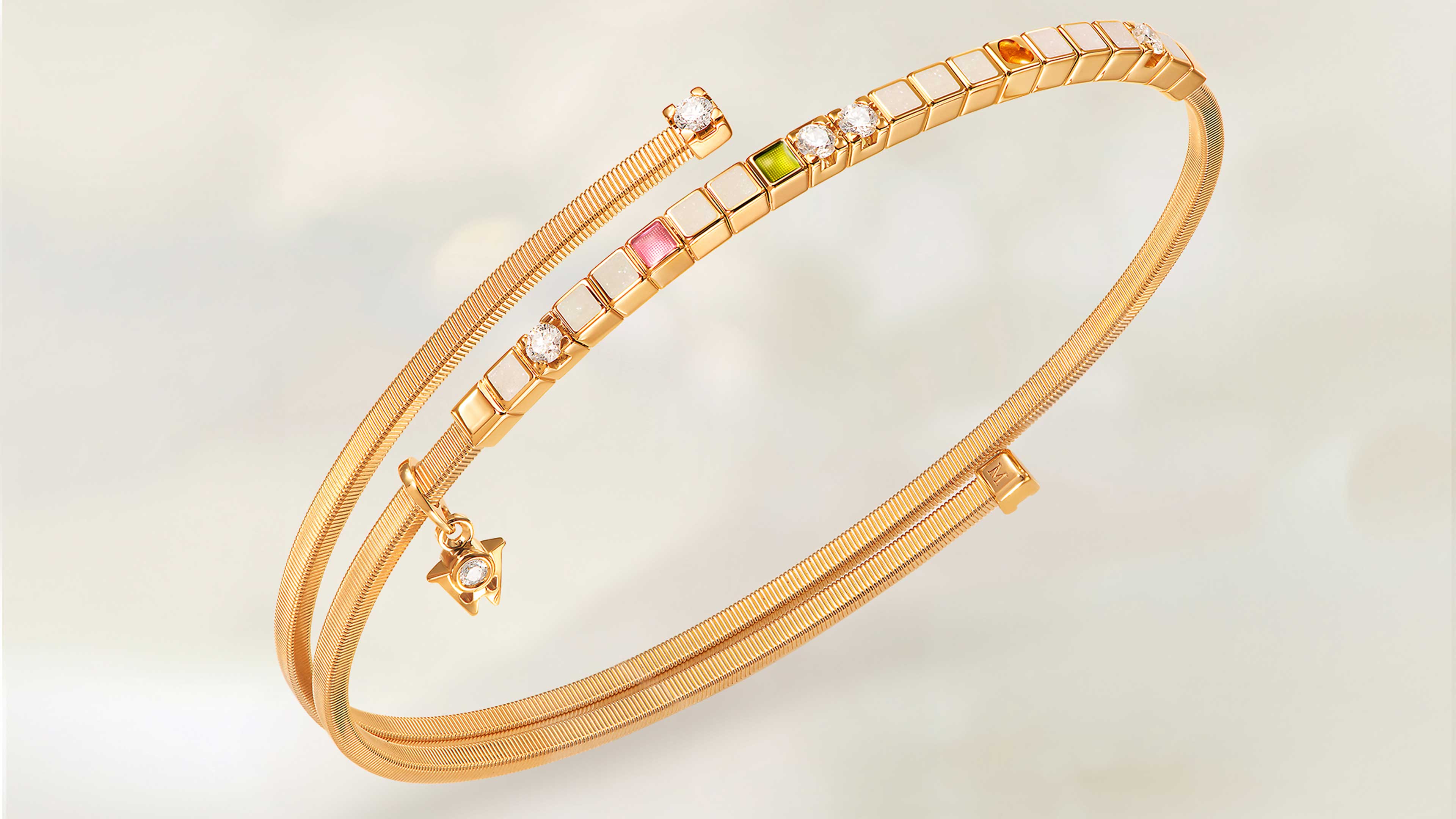 Das Wellendorff Armband UMARME MICH Power in white in 18-Karat Gelbgold auf beigem Mood Hintergrund