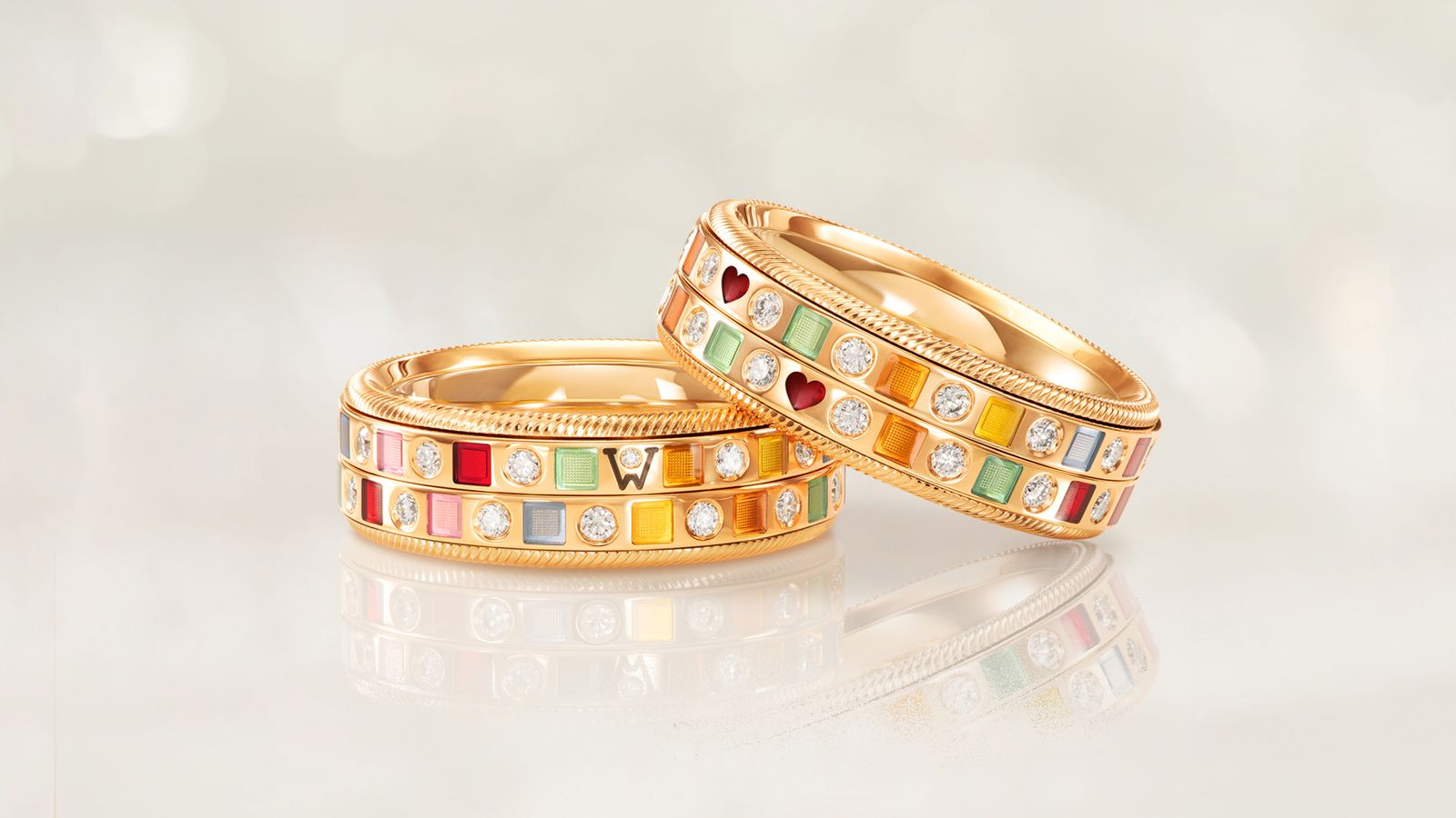 Der drehbare Ring REGENBORGEN Duett fängt die Farben des Regenbogens in 18 Karat Gold ein. Rhythmisch eingefasst funkeln die Brillanten. Auf grauem Mood Hintergrund.