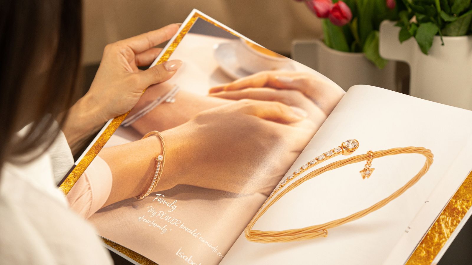 Wellendorff-Katalog mit den neuen POWER-Armbändern – Person entdeckt die Highlights der aktuellen Kollektion.