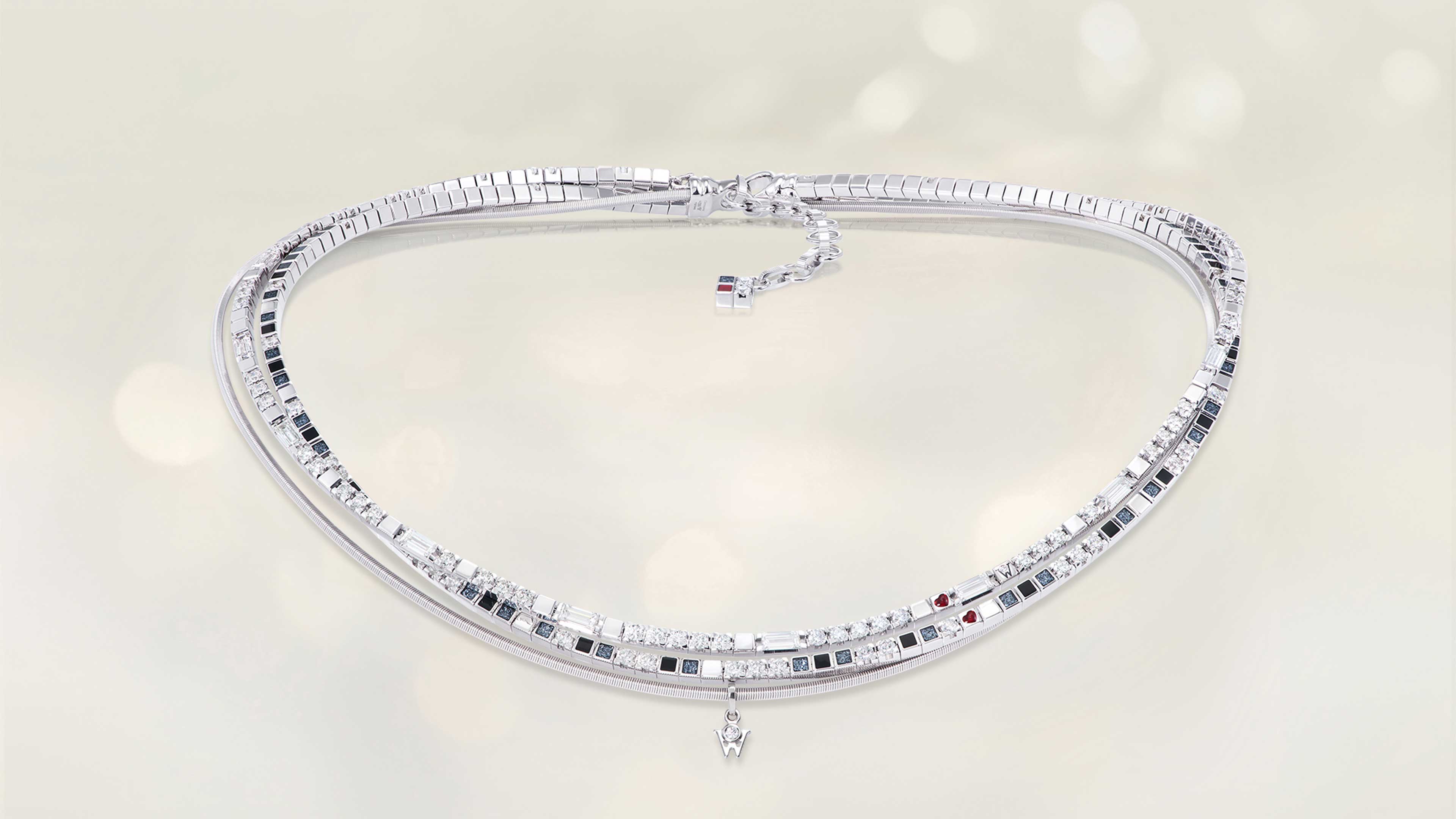 Das Collier POWER IN BLACK edel aus 18 Karat Weißgold verbindet schwarze Kaltemaille, feinen Sternenstaub, Brillant-Baguettestrang und ein kleines Herz. Collier auf hellem Hintergrund.