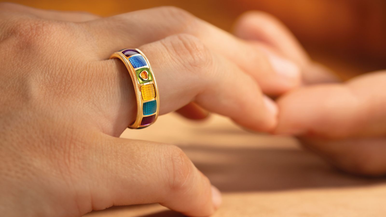 Der limitierte Geburtstagsring MEINE WELT IST BUNT aus 18 Karat Gelbgold und acht neuen Farben - an der Hand getragen.
