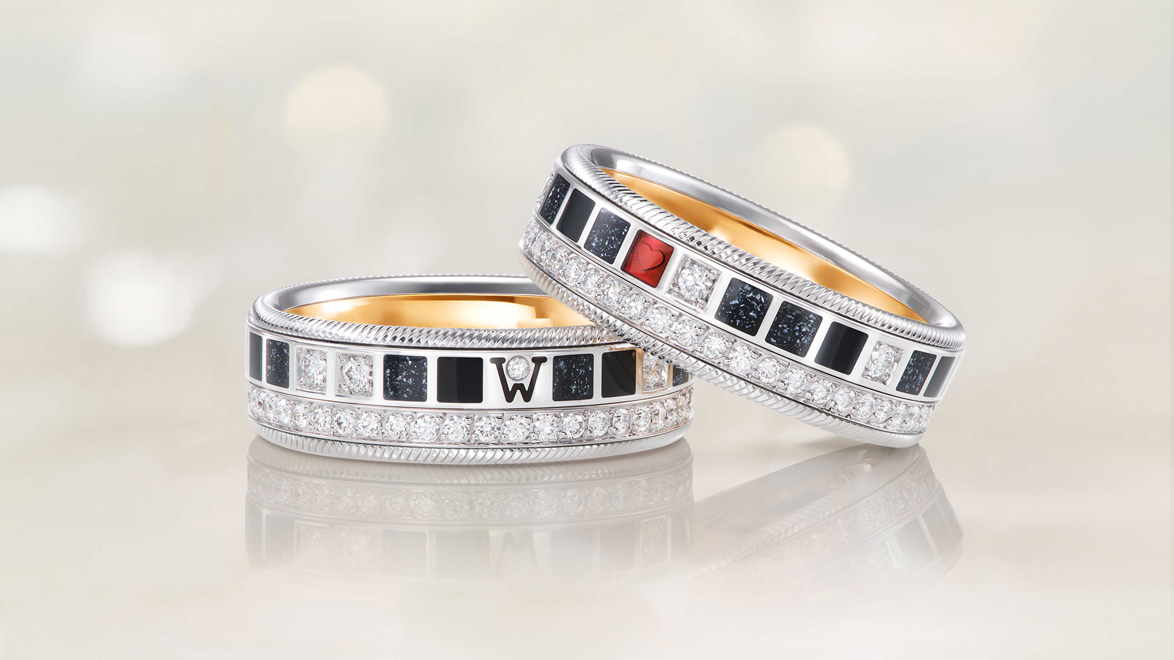 Der Ring POWER IN BLACK aus 18 Karat Weißgold zeigt schwarze Kaltemaille mit Sternenstaub, ein rotes Herz und handgefasste Brillanten auf hellem Hintergrund.