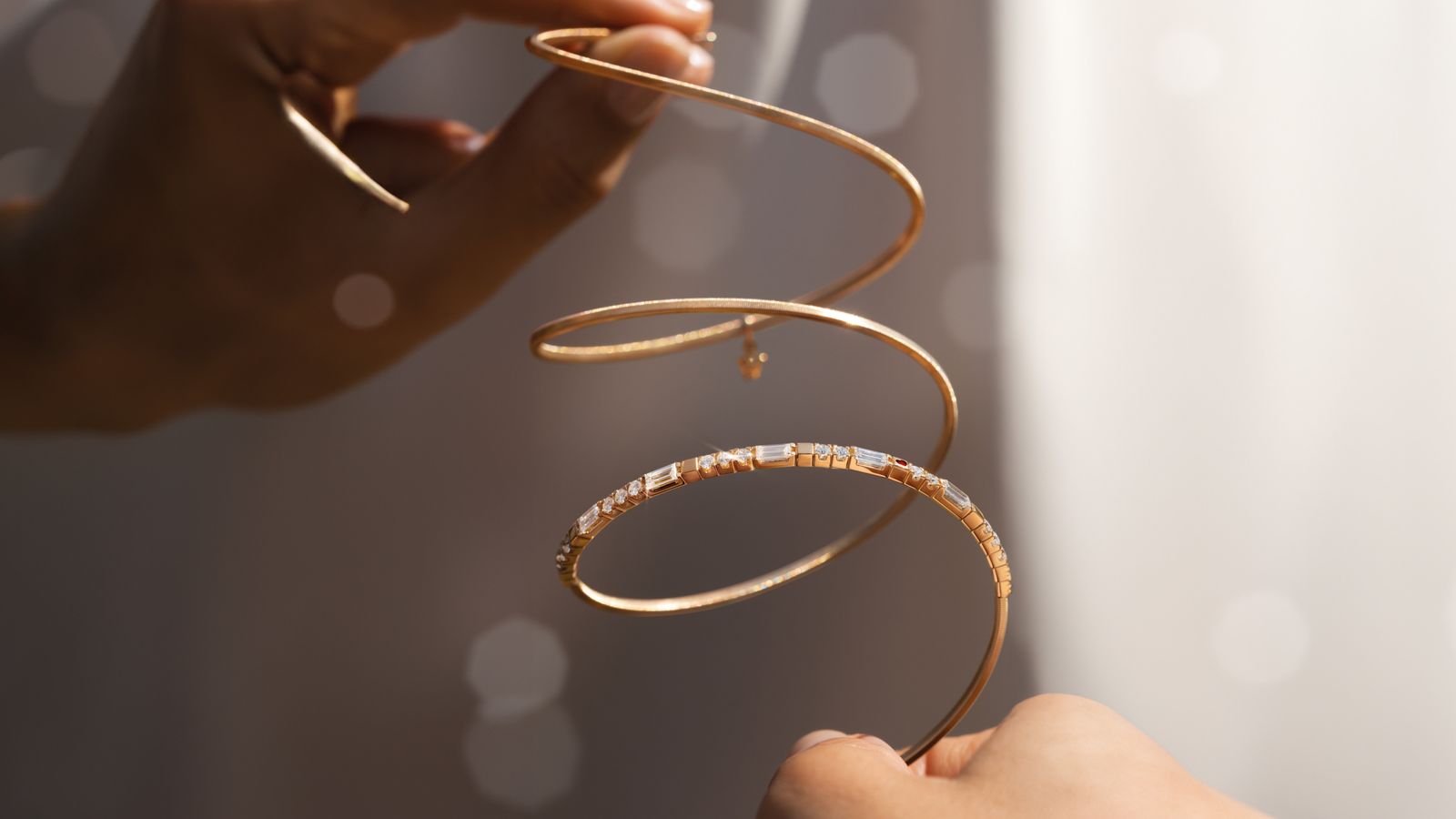 Das Armband UMARME MICH. Baguette-Zauber aus federndem 18-Karat Gelbgold, gepaart mit handgefassten Baguette-Diamanten und einem tiefroten Herz.